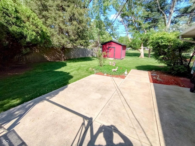 view of patio with a storage shed, fence, and an outbuilding