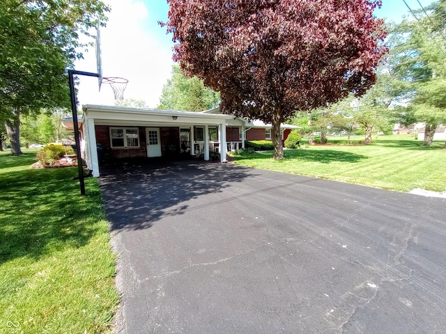 single story home featuring a front yard, an attached carport, and aphalt driveway