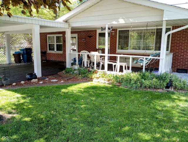 exterior space with a porch, brick siding, and a lawn