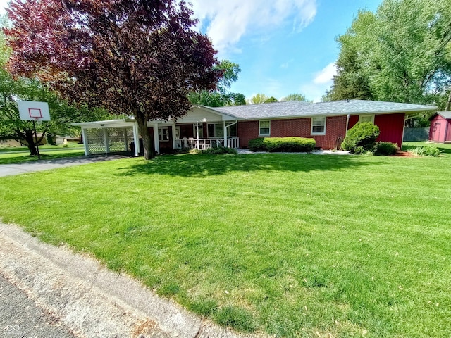 ranch-style house with a storage shed, a carport, an outdoor structure, a front yard, and driveway