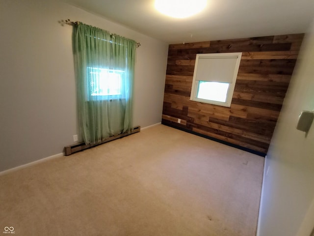empty room with wooden walls, baseboard heating, and carpet floors