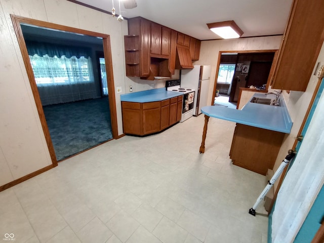 kitchen with white electric range oven, a sink, open shelves, brown cabinetry, and light countertops