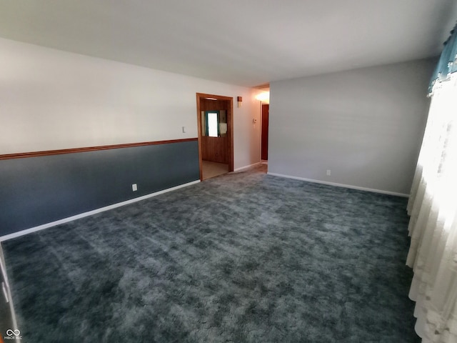 spare room featuring dark colored carpet