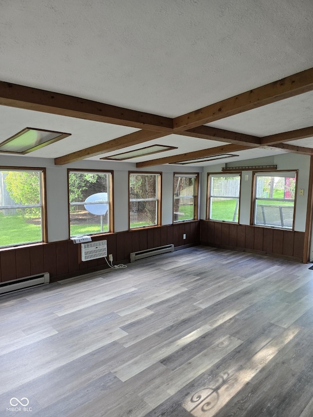interior space with beamed ceiling, a healthy amount of sunlight, and a baseboard heating unit