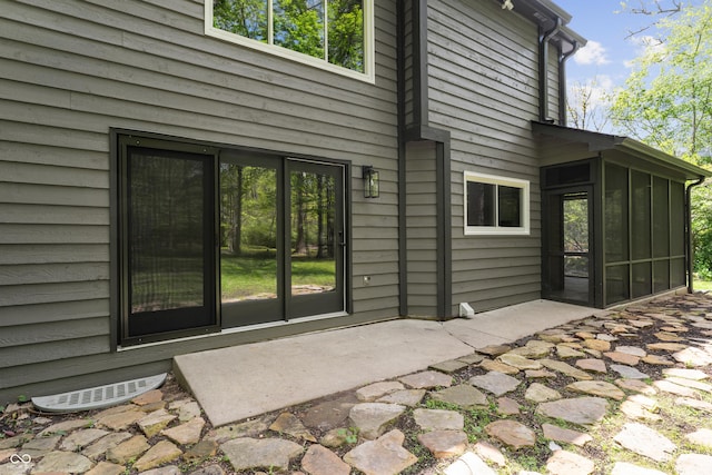 rear view of property featuring a sunroom and a patio area