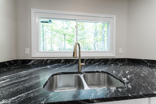 kitchen view of a sink and dark stone counters