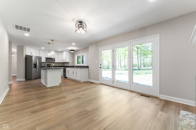 kitchen with stainless steel appliances, dark countertops, baseboards, white cabinetry, and recessed lighting