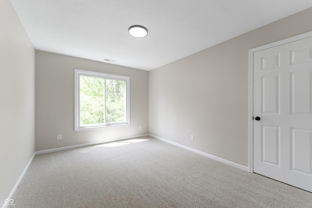 carpeted empty room with baseboards