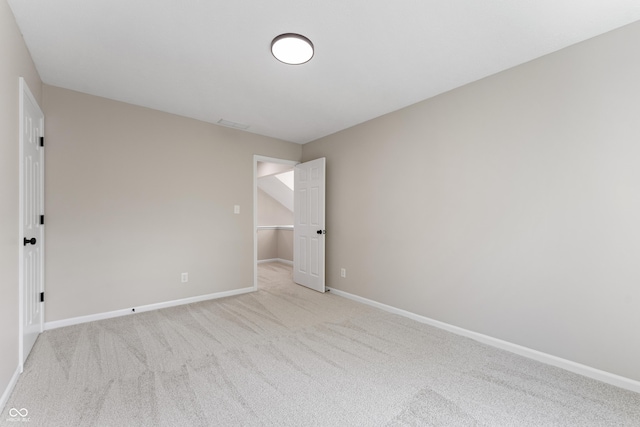 spare room with light colored carpet and baseboards