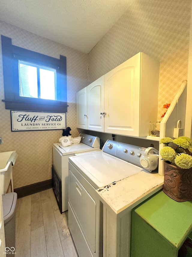 2119 S Garfield Dr, Indianapolis, IN 46203 - laundry room featuring separate washer and dryer, cabinet space, light wood-style floors, and wallpapered walls