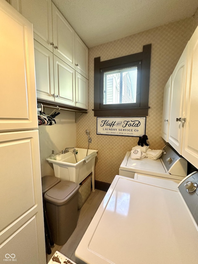 2119 S Garfield Dr, Indianapolis, IN 46203 - washroom featuring cabinet space, washing machine and clothes dryer, wallpapered walls, and baseboards