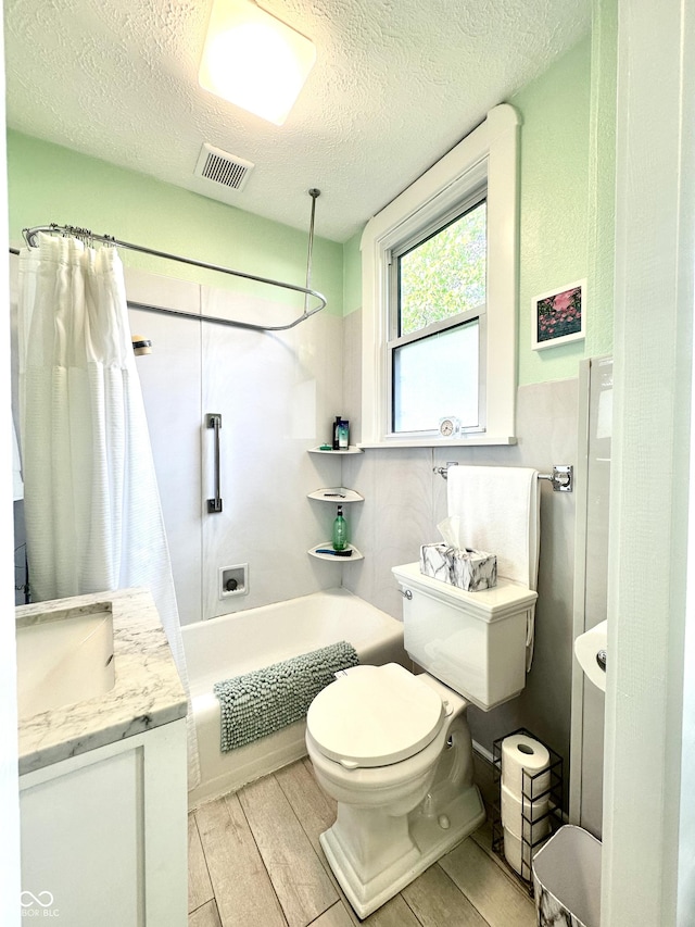 2119 S Garfield Dr, Indianapolis, IN 46203 - full bathroom with shower / bath combination with curtain, wood finished floors, a textured ceiling, toilet, and vanity