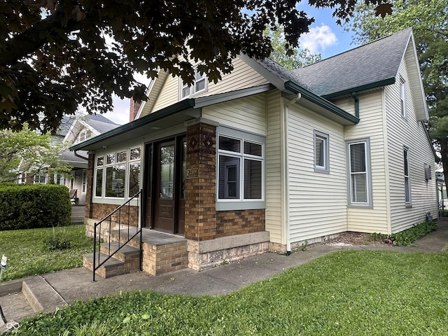 2119 S Garfield Dr, Indianapolis, IN 46203 - view of home's exterior with entry steps, a yard, and roof with shingles