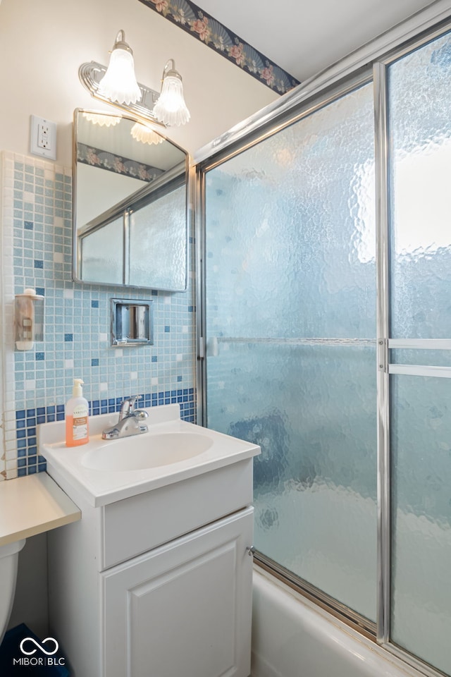 bathroom with tile walls, enclosed tub / shower combo, vanity, and tasteful backsplash