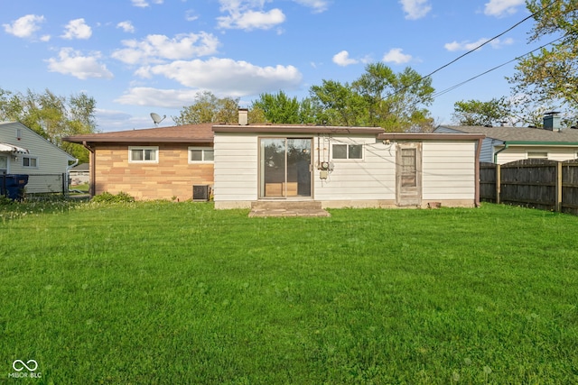 back of house with a yard, fence, and a chimney