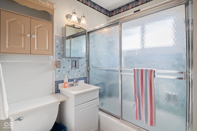 bathroom with enclosed tub / shower combo, toilet, tile walls, and vanity