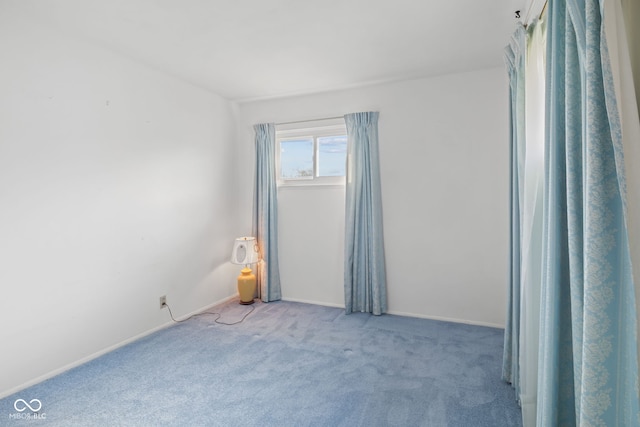 spare room with baseboards and carpet flooring