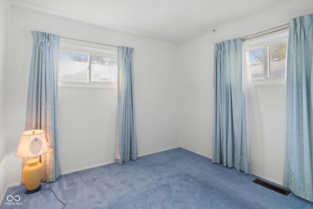 empty room with baseboards, carpet, and visible vents