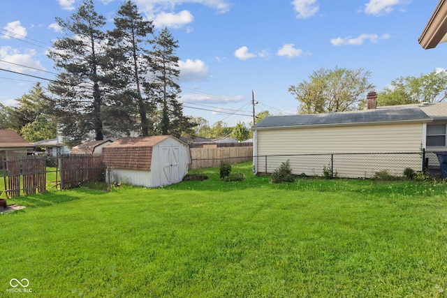 view of yard featuring a fenced backyard, a storage unit, and an outbuilding
