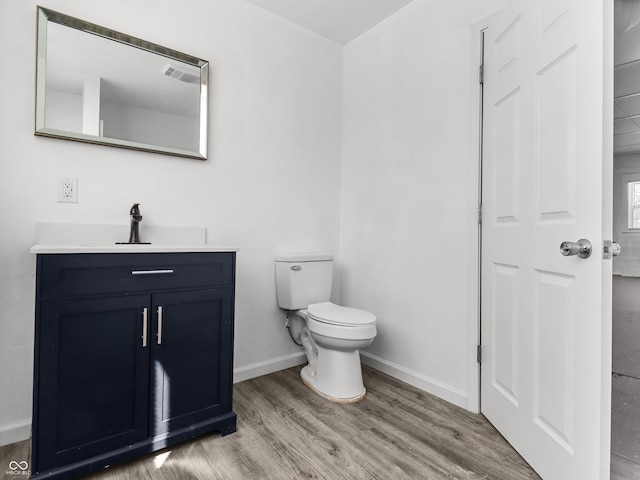 1630 N Granville Ave N, Muncie, IN 47303 - bathroom featuring baseboards, wood finished floors, toilet, and vanity