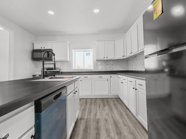 1630 N Granville Ave N, Muncie, IN 47303 - kitchen featuring white cabinets, dark countertops, decorative backsplash, light wood-type flooring, and black appliances