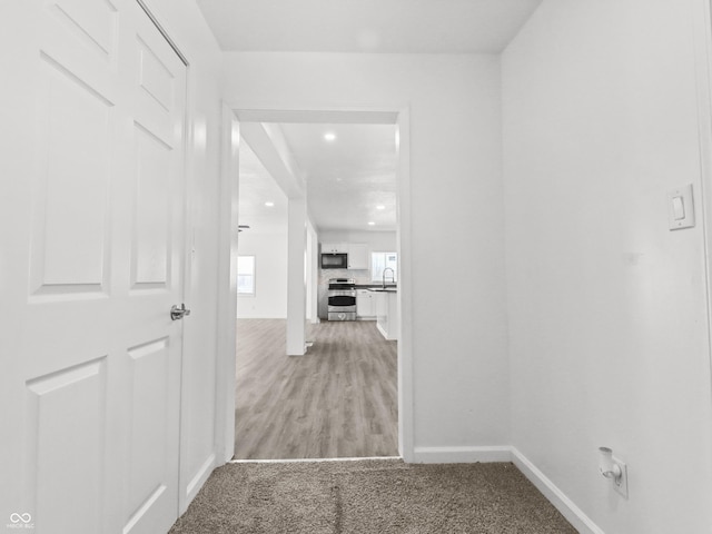 1630 N Granville Ave N, Muncie, IN 47303 - hall with recessed lighting, baseboards, light colored carpet, and a sink