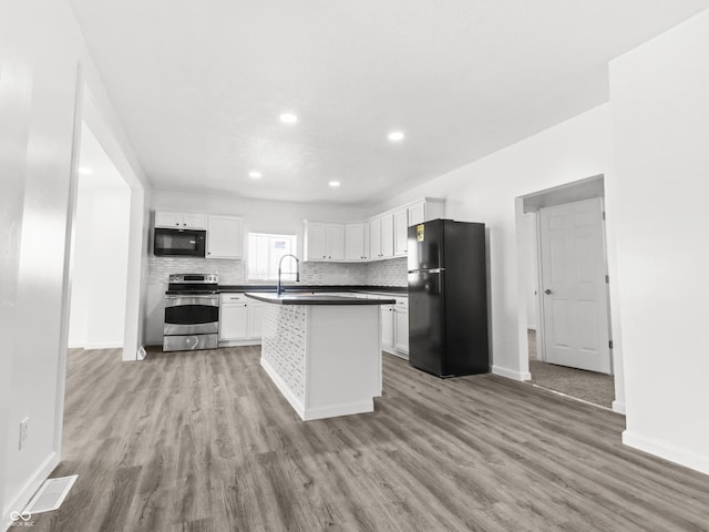1630 N Granville Ave N, Muncie, IN 47303 - kitchen featuring baseboards, visible vents, light wood finished floors, and black appliances