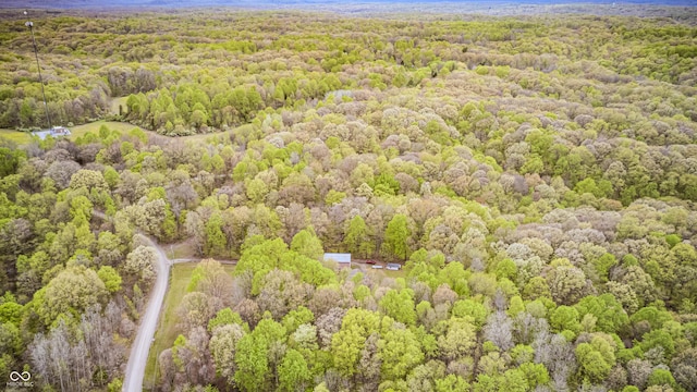 drone / aerial view featuring a wooded view