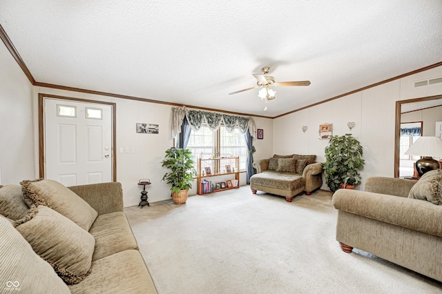 carpeted living area featuring crown molding, a ceiling fan, a textured ceiling, and visible vents