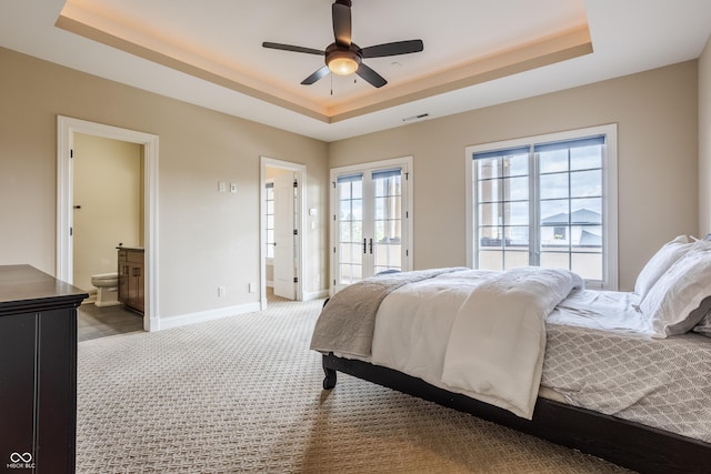 carpeted bedroom featuring french doors, visible vents, a raised ceiling, connected bathroom, and baseboards