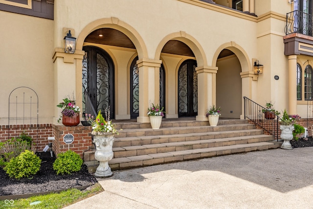 entrance to property with covered porch and stucco siding