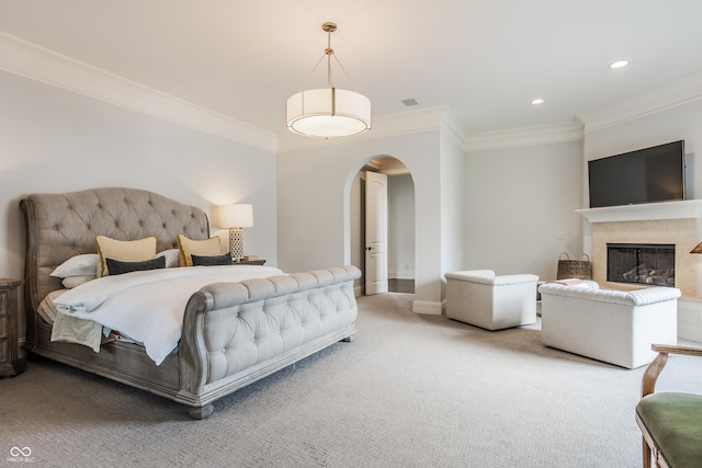 carpeted bedroom with arched walkways, recessed lighting, baseboards, and crown molding