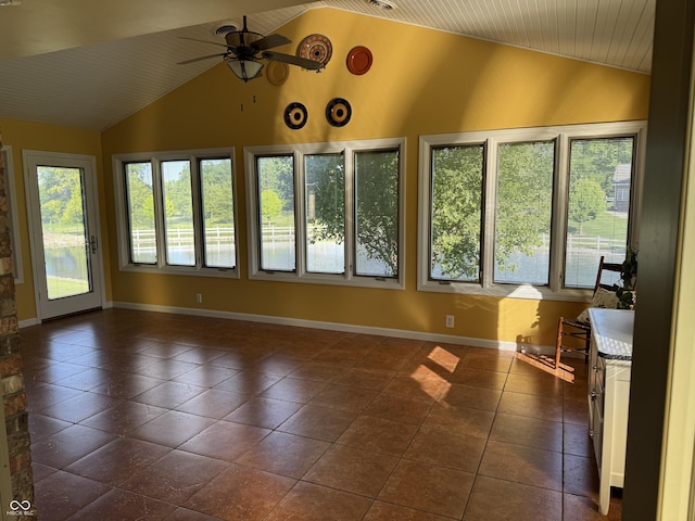 unfurnished sunroom featuring vaulted ceiling, plenty of natural light, tile patterned flooring, baseboards, and wooden ceiling