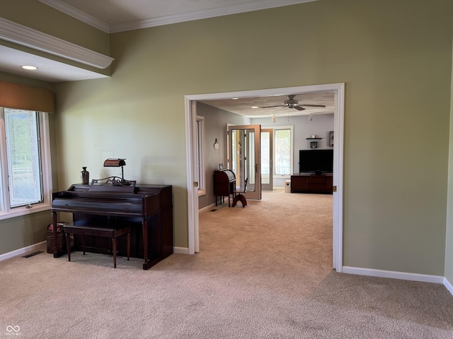 sitting room featuring carpet flooring, baseboards, ornamental molding, and a ceiling fan
