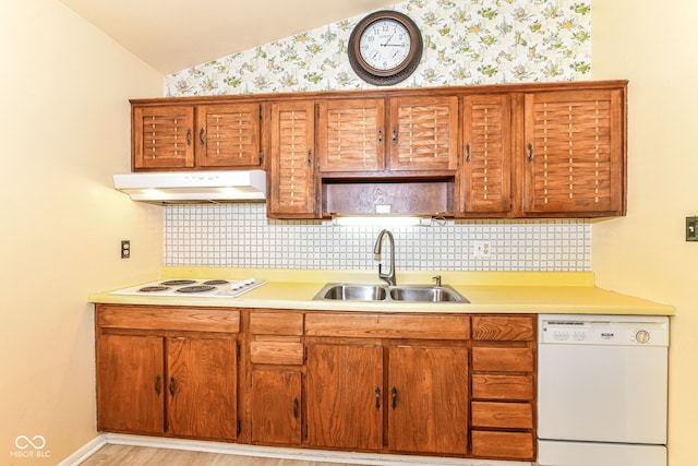kitchen featuring white appliances, under cabinet range hood, a sink, light countertops, and wallpapered walls