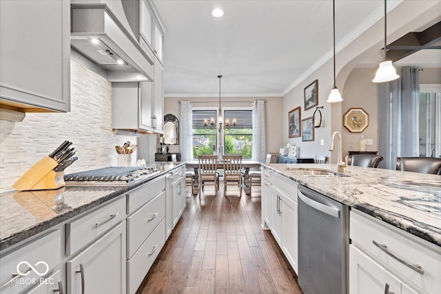 1013 Domino Dr, Carmel, IN 46032 - kitchen with crown molding, an inviting chandelier, a sink, stainless steel appliances, and custom range hood