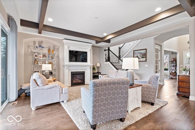 1013 Domino Dr, Carmel, IN 46032 - living room with arched walkways, wood finished floors, a wealth of natural light, and beamed ceiling