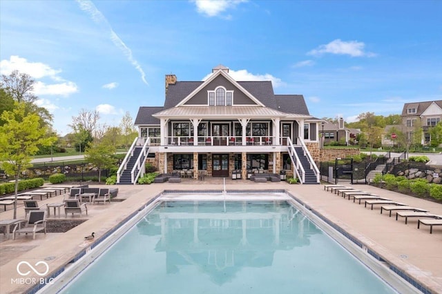 1013 Domino Dr, Carmel, IN 46032 - rear view of house featuring a community pool, a chimney, a patio area, and stairway
