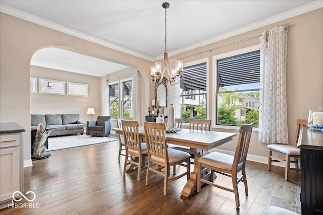 1013 Domino Dr, Carmel, IN 46032 - dining room featuring crown molding, arched walkways, wood finished floors, baseboards, and a chandelier