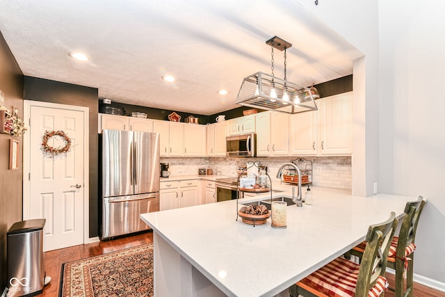 12092 Sugar Creek Rd, Noblesville, IN 46060 - kitchen featuring stainless steel appliances, a sink, a peninsula, wood finished floors, and recessed lighting