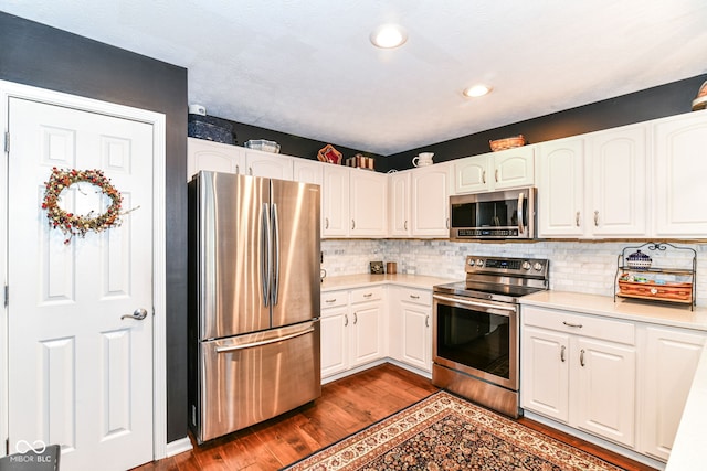 12092 Sugar Creek Rd, Noblesville, IN 46060 - kitchen featuring appliances with stainless steel finishes, dark wood-type flooring, white cabinetry, decorative backsplash, and recessed lighting