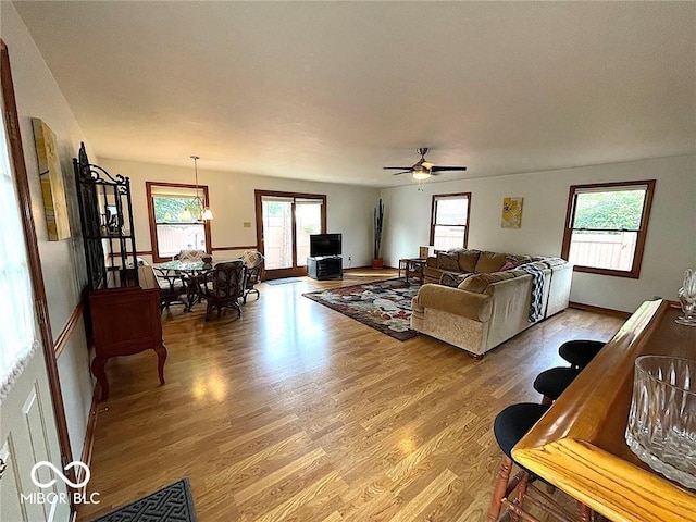 living room with light wood-style flooring and ceiling fan