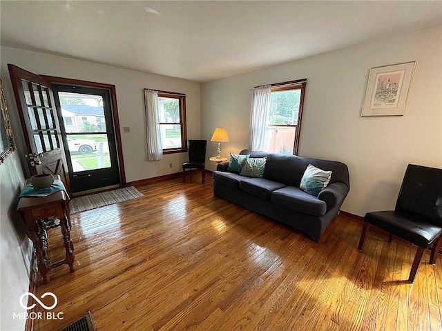 living room with baseboards, plenty of natural light, and hardwood / wood-style floors