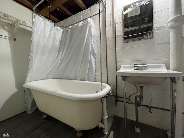 bathroom featuring a soaking tub and wood finished floors