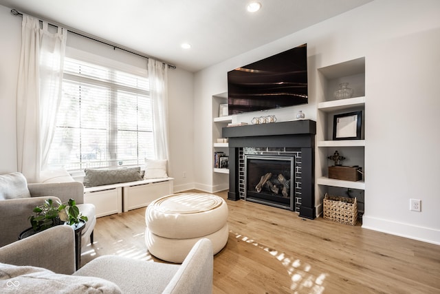 544 N Beville Ave, Indianapolis, IN 46201 - living room with light wood-style flooring, a tile fireplace, recessed lighting, built in shelves, and baseboards