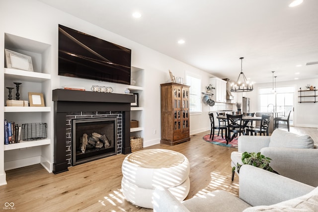 544 N Beville Ave, Indianapolis, IN 46201 - living area with light wood finished floors, a fireplace, baseboards, a chandelier, and recessed lighting