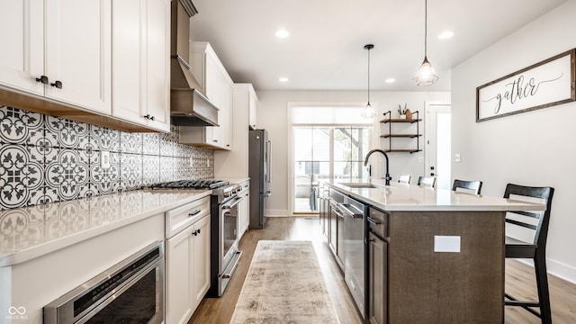 544 N Beville Ave, Indianapolis, IN 46201 - kitchen featuring appliances with stainless steel finishes, light wood-type flooring, light countertops, a center island with sink, and a sink