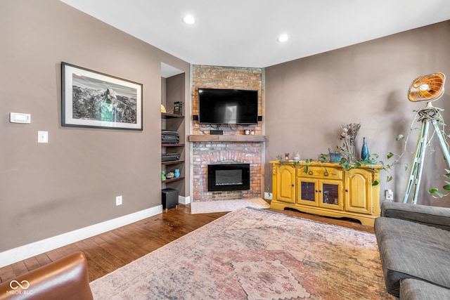 715 Terrace Ave, Indianapolis, IN 46203 - living area featuring wood finished floors, a brick fireplace, recessed lighting, and built in features
