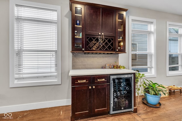 715 Terrace Ave, Indianapolis, IN 46203 - indoor dry bar featuring wine cooler, light wood finished floors, and tasteful backsplash