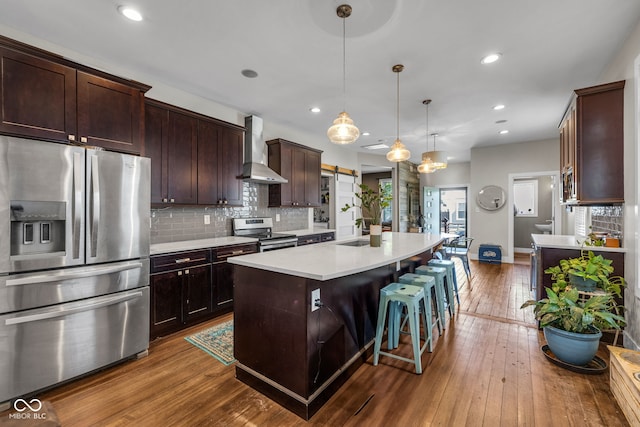 715 Terrace Ave, Indianapolis, IN 46203 - kitchen with appliances with stainless steel finishes, wall chimney exhaust hood, dark wood finished floors, light countertops, and backsplash